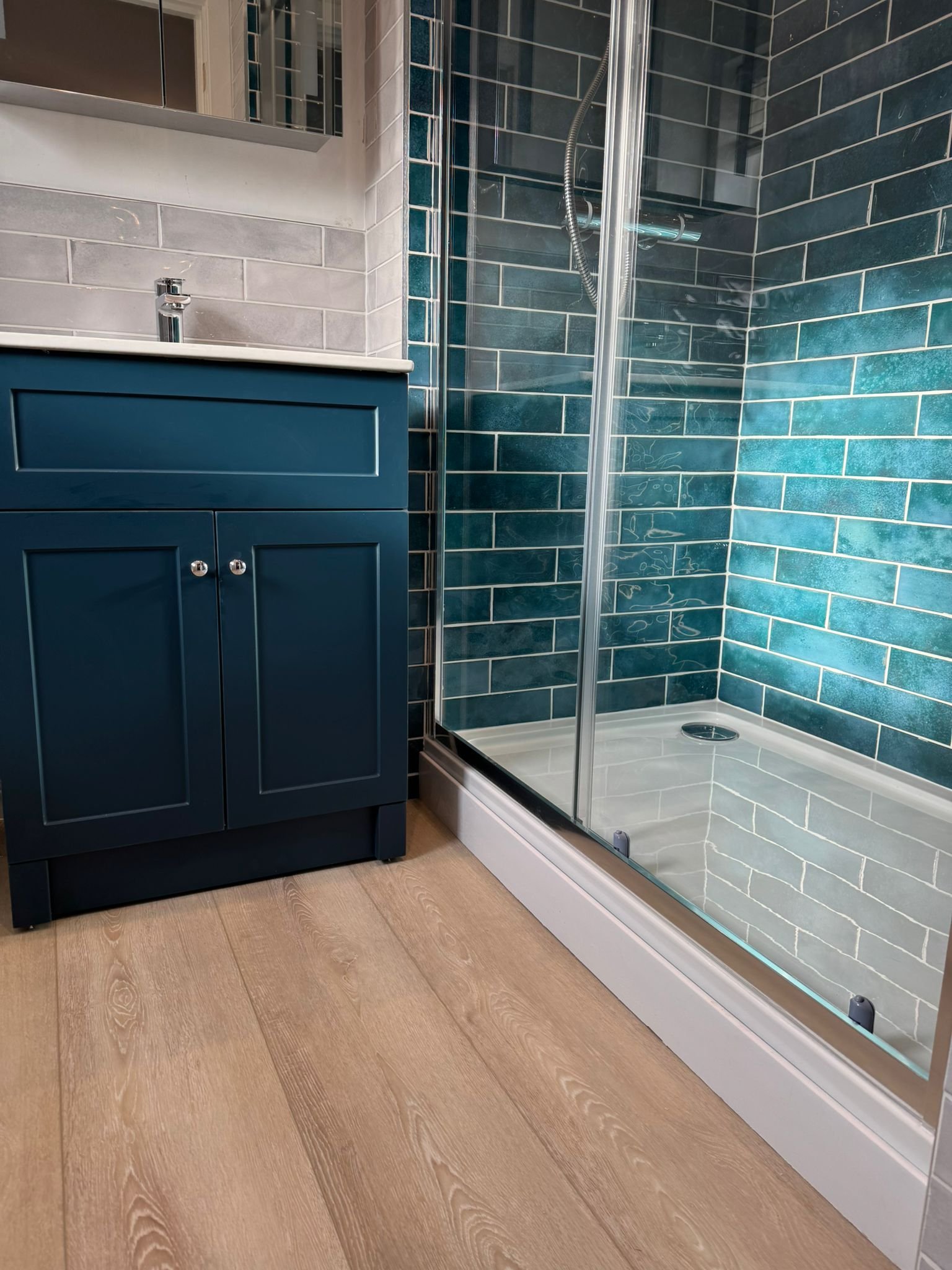 Modern ensuite upgrade completed in Spalding with feature wall tiles, shower enclosure, vanity unit, and WC installation.